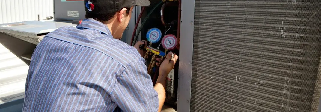 HVAC technician servicing a condenser unit in Marietta